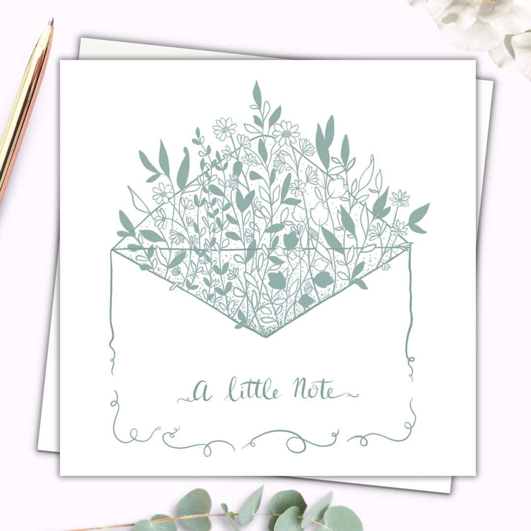 Image shows a botanical themed note card which is itself an illustration of an envelope. Out of the envelope are lots of leaves petals and little wildflowers, in green and white. On the front of the envelope it says "A Little Note" in handwritten script writing in the same sage green as the rest of the card.