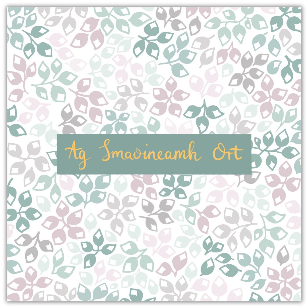 Botanical themed greeting card with simple floral buds of different colours. The colour palette is various shades of green, grey and dusty pink. In the centre of the card are the Gaeilge words "Ag Smaoineamh Ort" in gold writing on a dark green background. Ag Smaoineamh Ort is the Irish language version of the thoughtful phrase "Thinking of You".