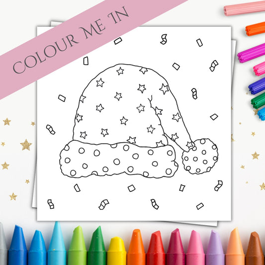 Image shows a Christmas card that is made for colouring in. The front of it is a simple and playful design of a Santa Hat. On the Santa Hat there are stars and circles to colour in and surrounding the hat there are confetti for colouring too. Surrounding the card are a mixture of markers and crayons to give some colour to the picture and show the purpose of the card. On the top right corner of the image there is a banner which says "Colour Me In".