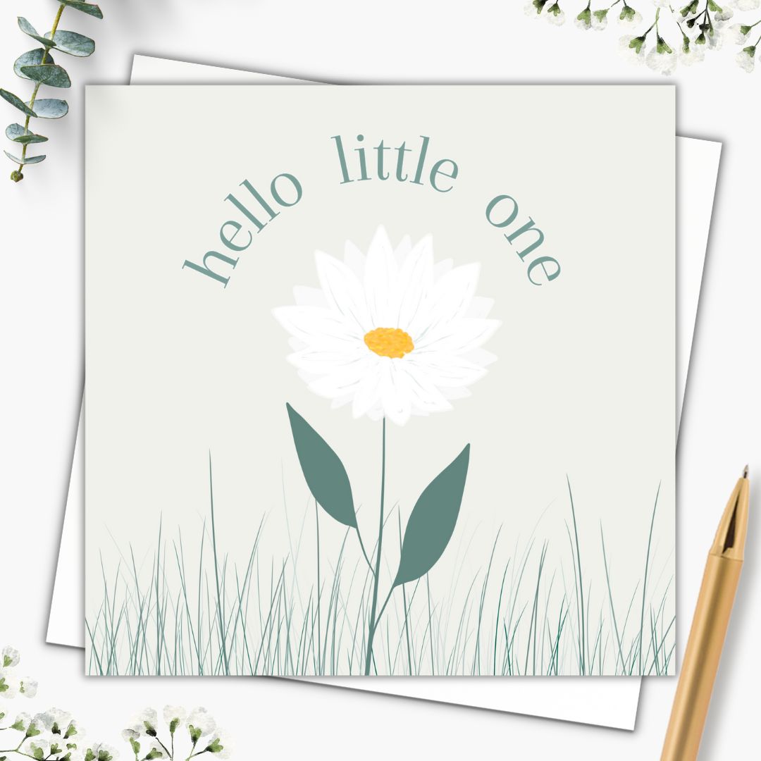 New baby bard with the words "Hello Little One" in a dark green font which circle around the head of a daisy. The daisy is illustrated with white petals, and an orange centre. There are two big dark green leaves and little sprigs of grass growing around it. The background of the card is a faint soft green to make this a very natural looking gender neutral baby card. symbolizing growth, flowering, and nature.