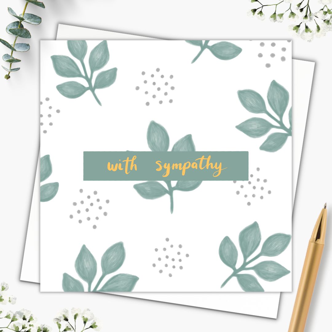 Our sympathy card has the words "with sympathy" written in the centre in a gold hand writing. It's framed by a small sage green rectangle. Behind it the card is made up of a simple cluster of five sage green leaves and little clusters of sage green dots. The card is simple, yet gentle and elegant in appearance with a natural feeling from the leaves and the colour. The card is set down on a plain white envelope and beside it there is a gold pen.