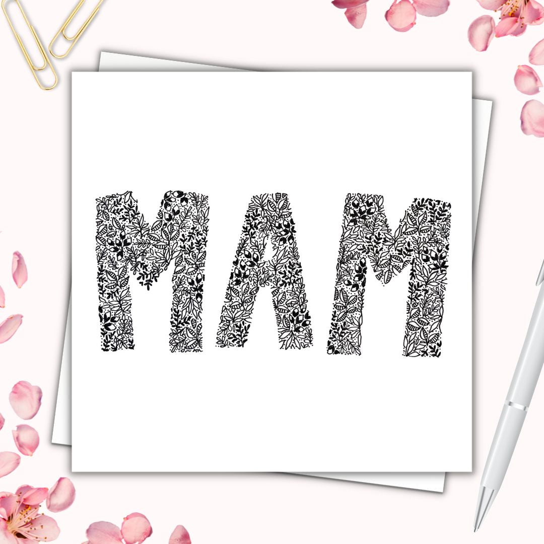 Image shows illustration card of MAM. image is made from a variety of floral drawings. Image is laid on a cream surface with pink flowers surrounding it. 